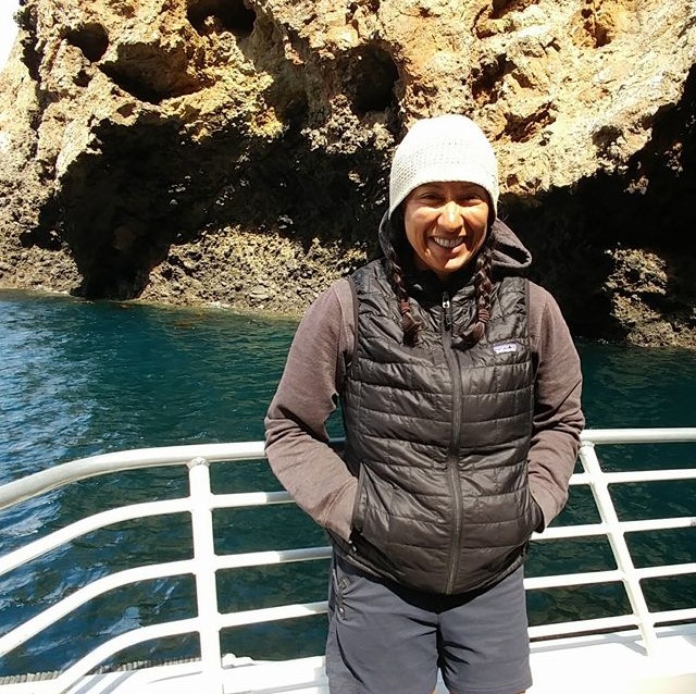 Rubayi in Santa Rosa, standing at a railing with water behind her