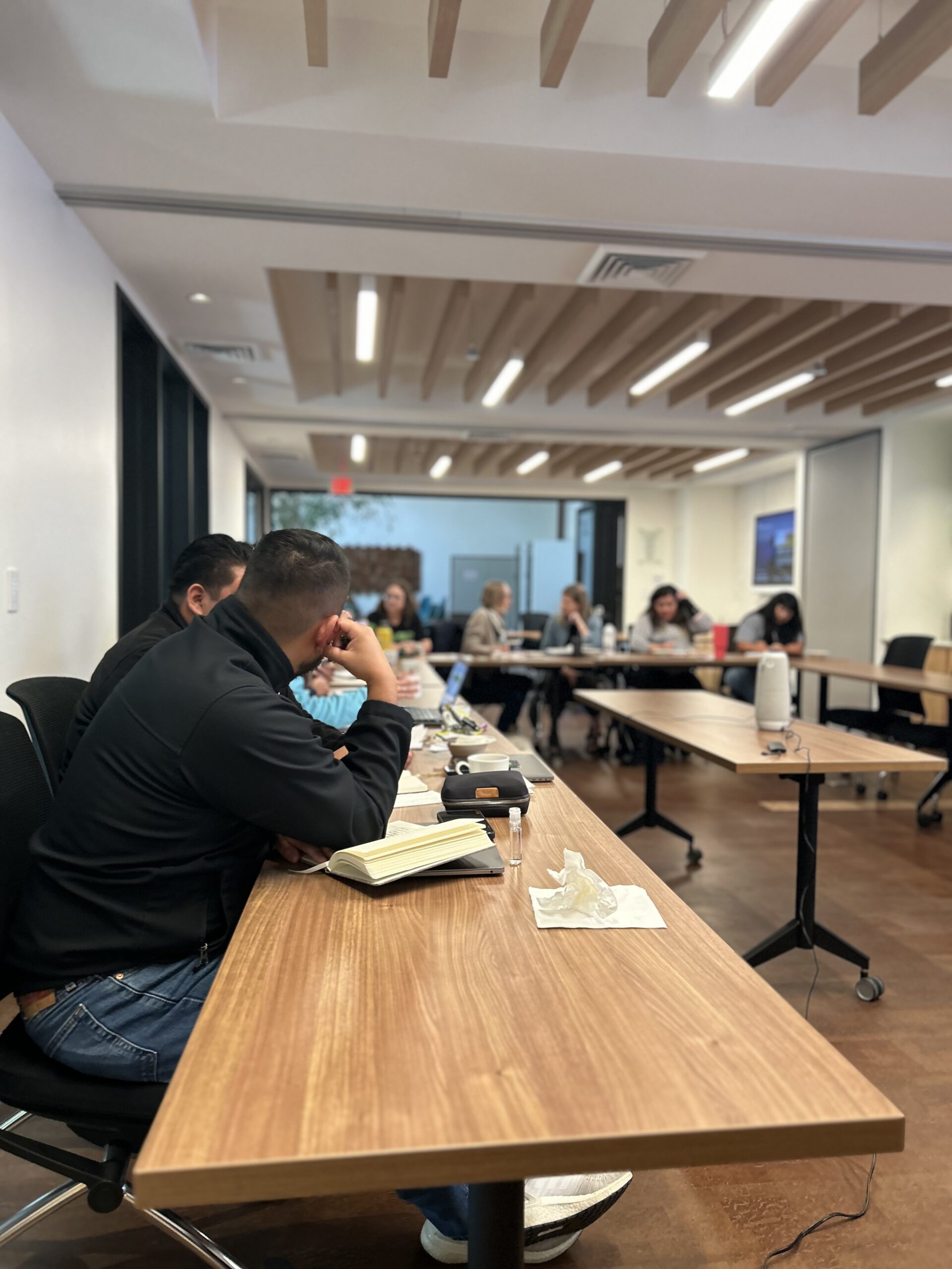 Workshop with people sitting at tables, as if in a presentation
